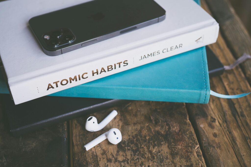 Business & Commercial Insurance An elegant arrangement of a smartphone, book, and AirPods on a wooden table.